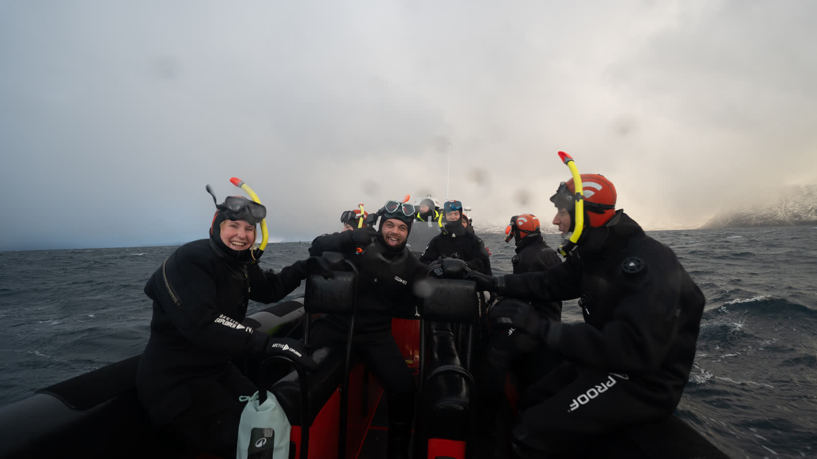 Participants en combinaison étanche, masque et tuba, à bord du bateau semi-rigide